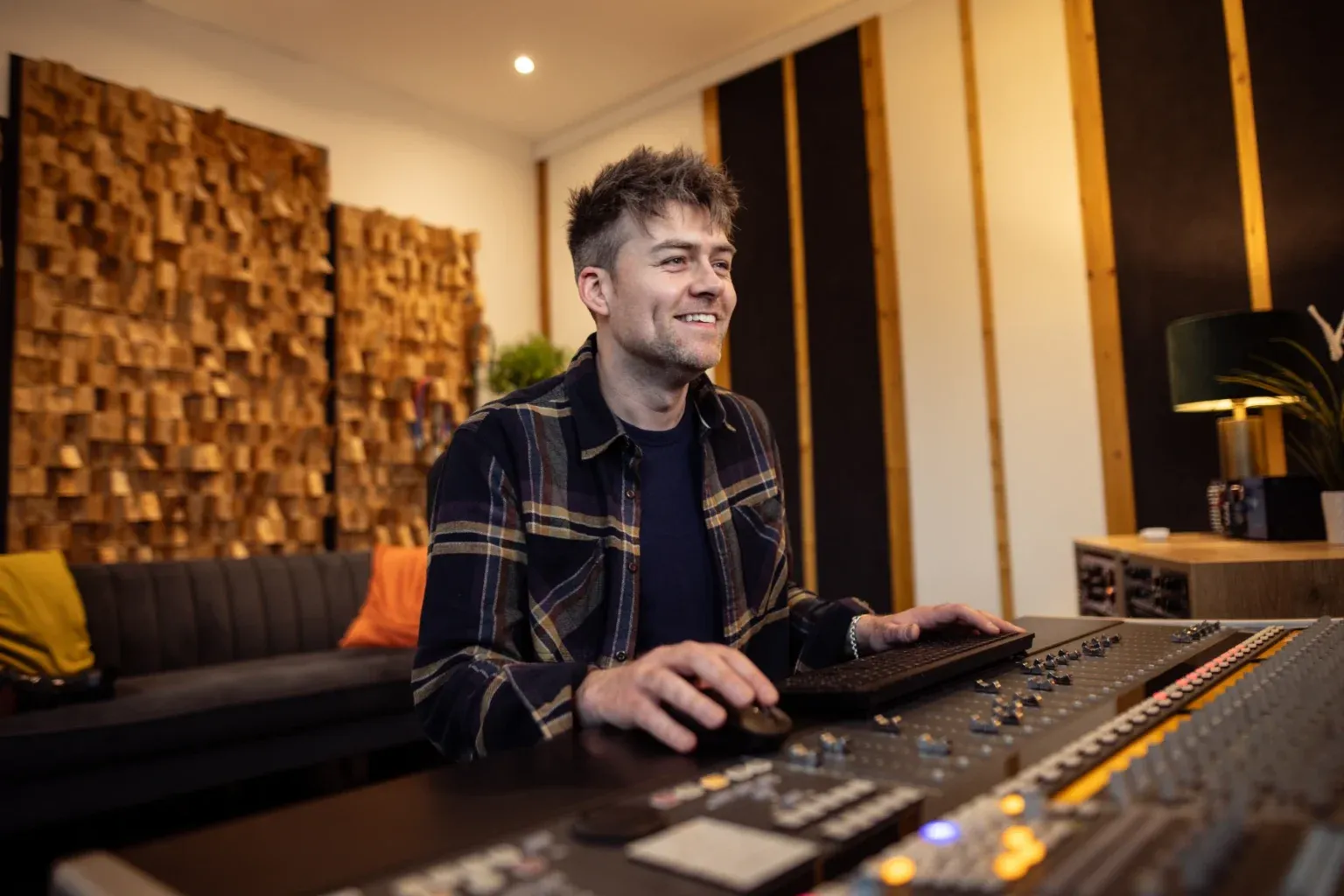 Conor Mangan smiling at a studio mixing desk
