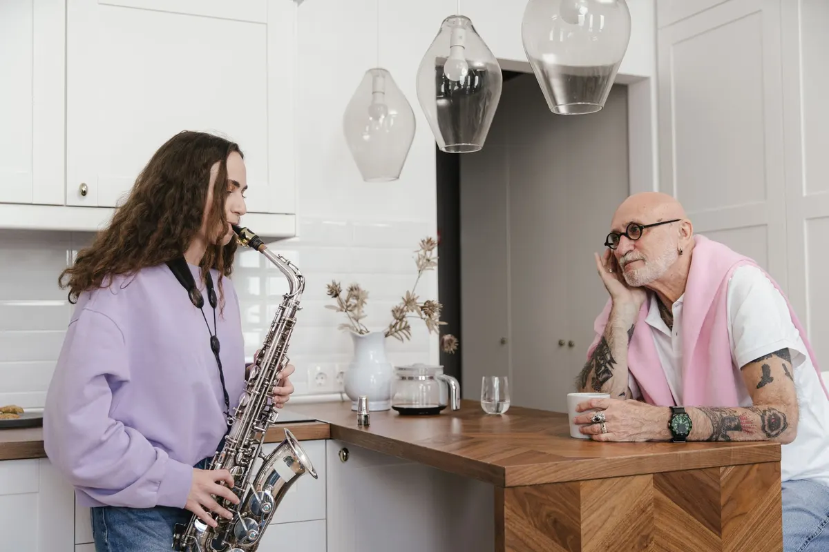 A teenage girl playing the saxophone in a kitchen at home